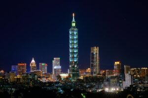 Illuminated Taipei 101 and city skyline at night showcasing modern urban architecture.