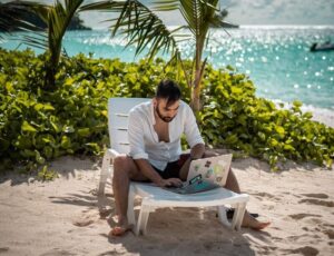 a man sitting on a beach reading a book